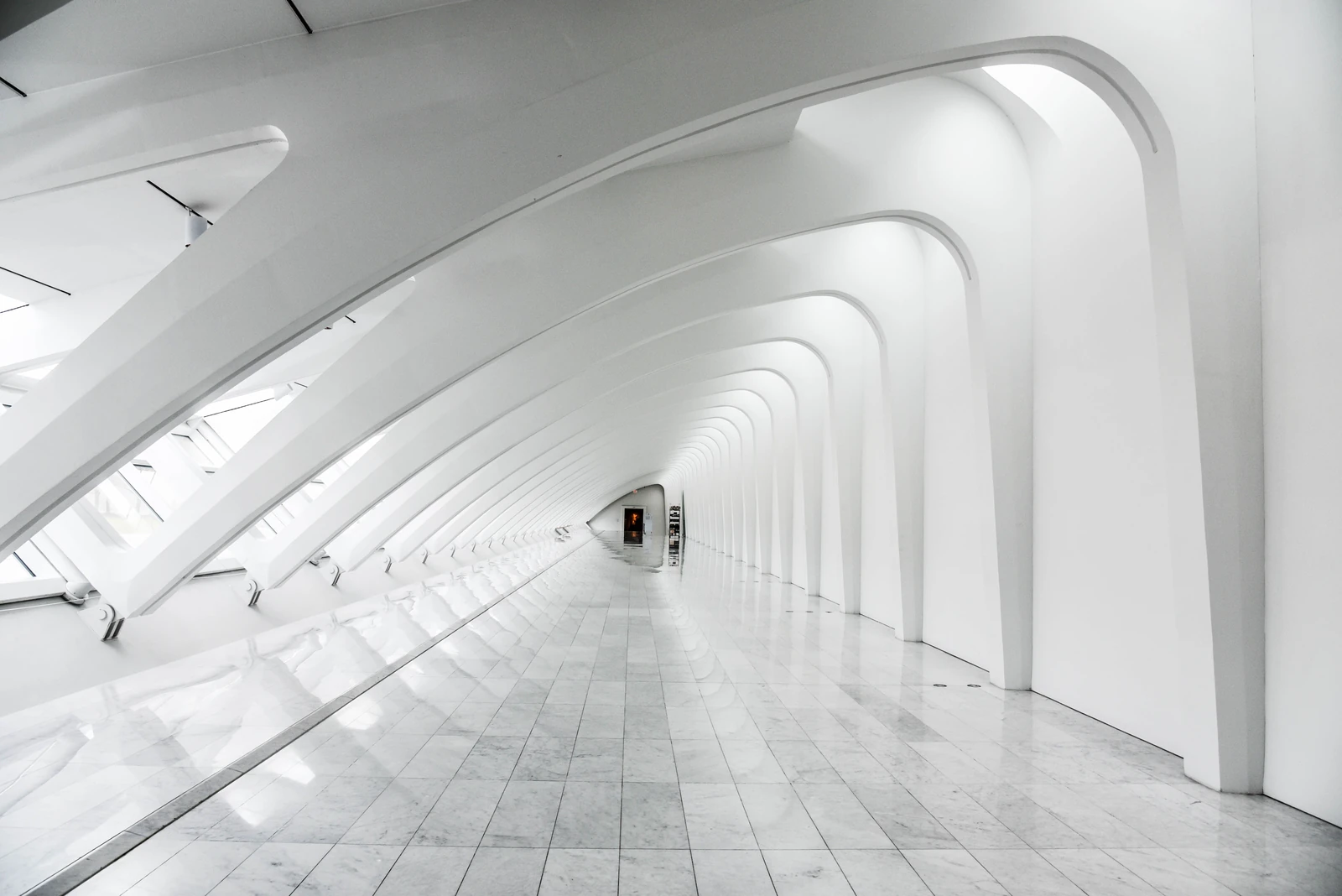 White curved arches in a long, light corridor